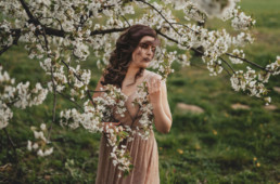 Kobieca sesja w kwitnącym sadzie